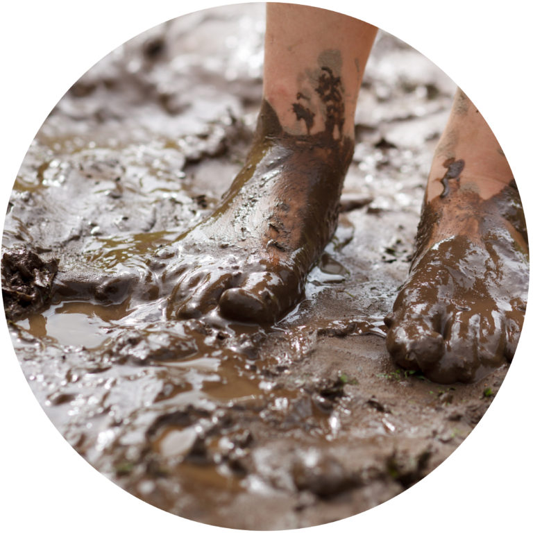 A child's muddy feet in mud