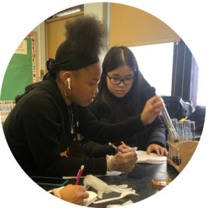High school students of color doing science lab work