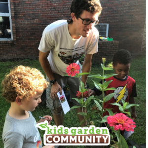 Two kids and a garden educator gather around pink zinnias. The Kids Garden Community logo is at the bottom of the photo.