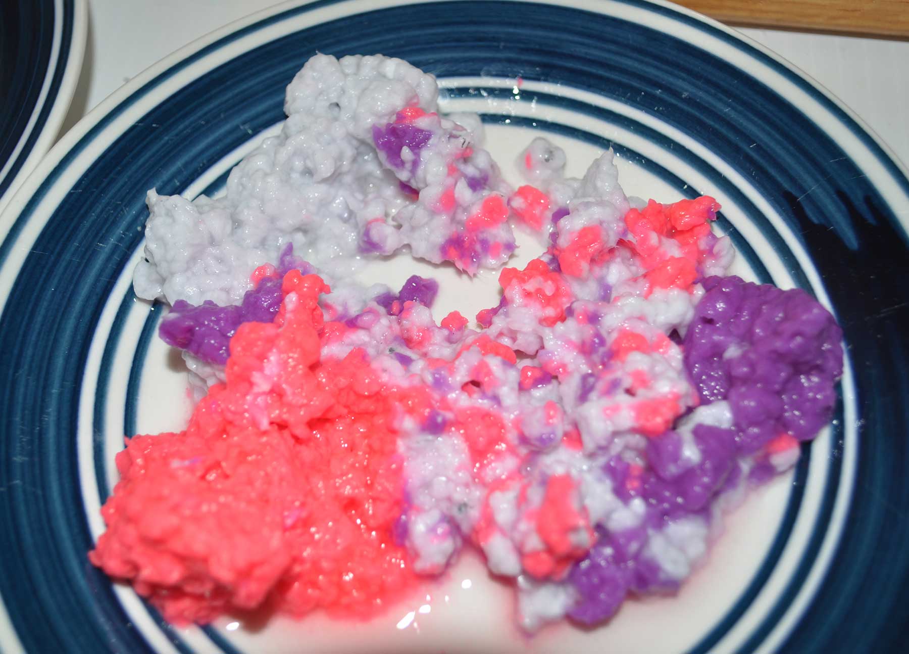 Mounds of pink, purple and white paper pulp on a plate
