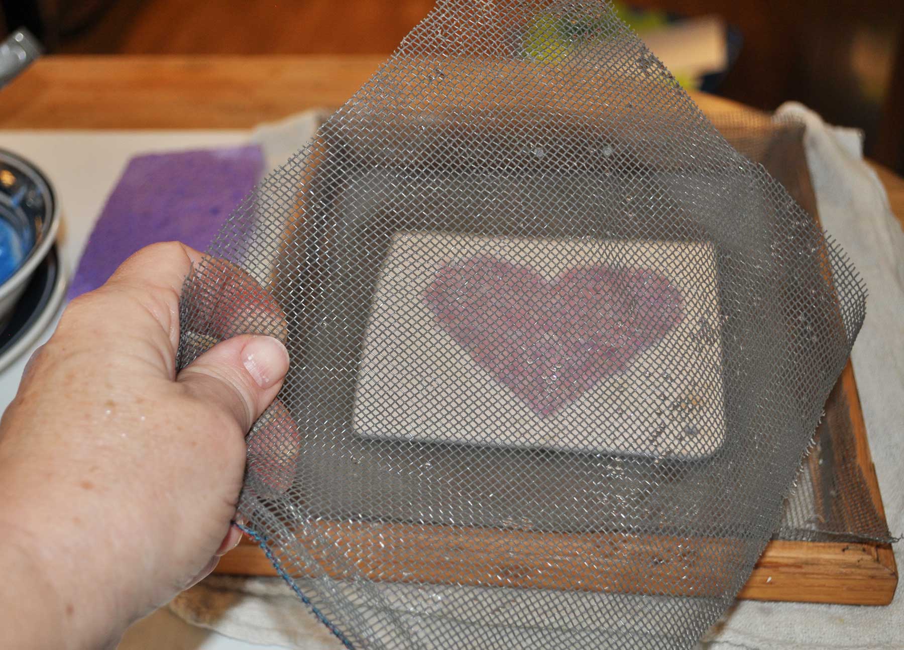 Laying a second piece of screen over the paper heart before flipping it