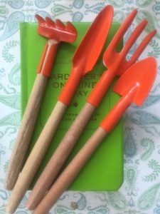 Four garden tools with red metal tops and wooden handles