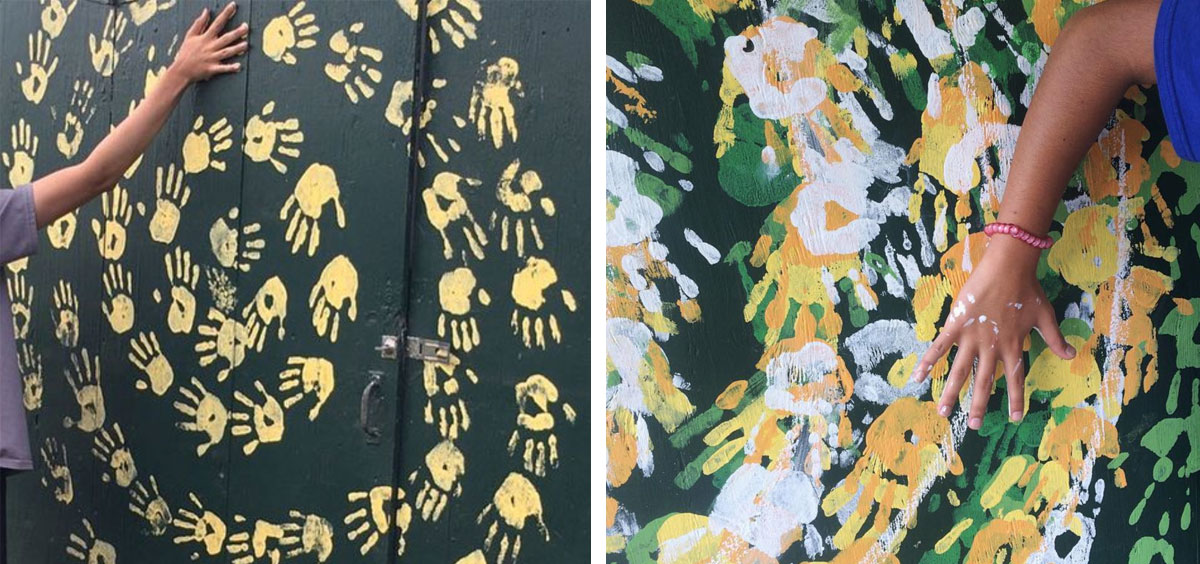 A side-by-side of two photos of hand-print murals. On the left, there is a black background and yellow handprints in a circular pattern. A child's arm is making one of the handprints. On the right there are white and green handprints layered on top of the yellow handprints. A child's hand is making one of the handprints.