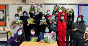 Students holding up bags of hydroponic lettuce