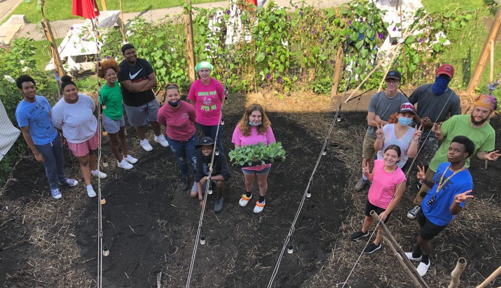 A group of students stands in a garden