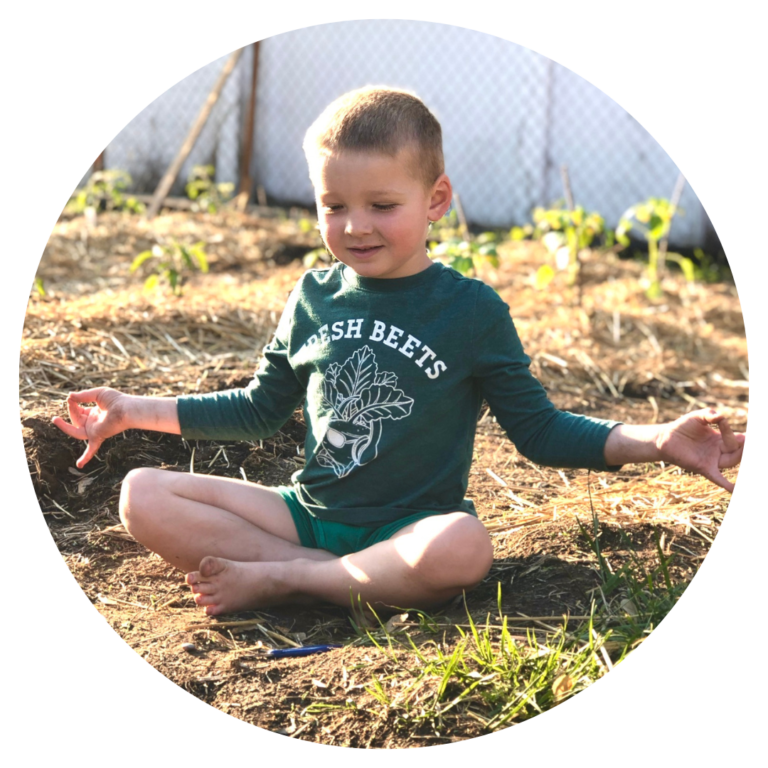 A child sitting with crossed legs and their arms out in a meditative pose