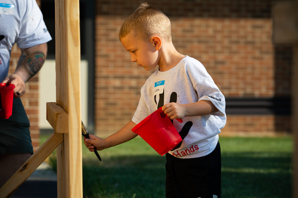 A child staining a picnic bench
