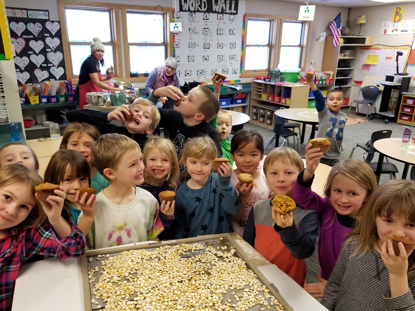 Kids in a classroom near a tray of pumpkin seeds