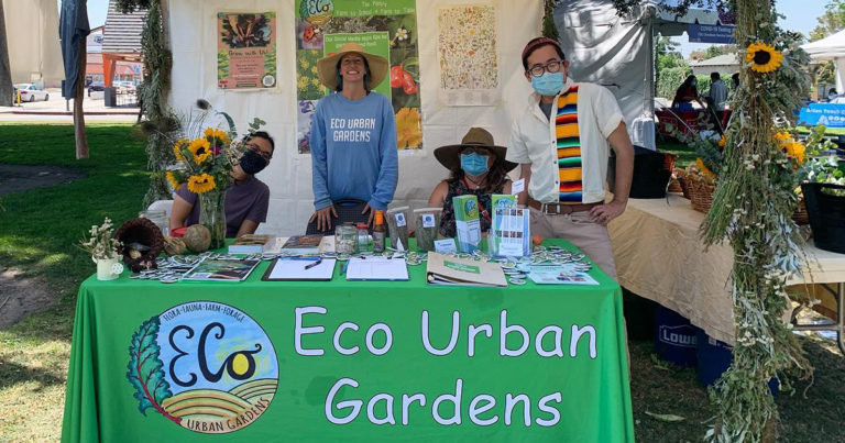 People behind a table that reads Eco Urban Gardens