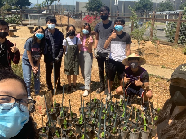 Teens in the garden, wearing masks and posing near plants