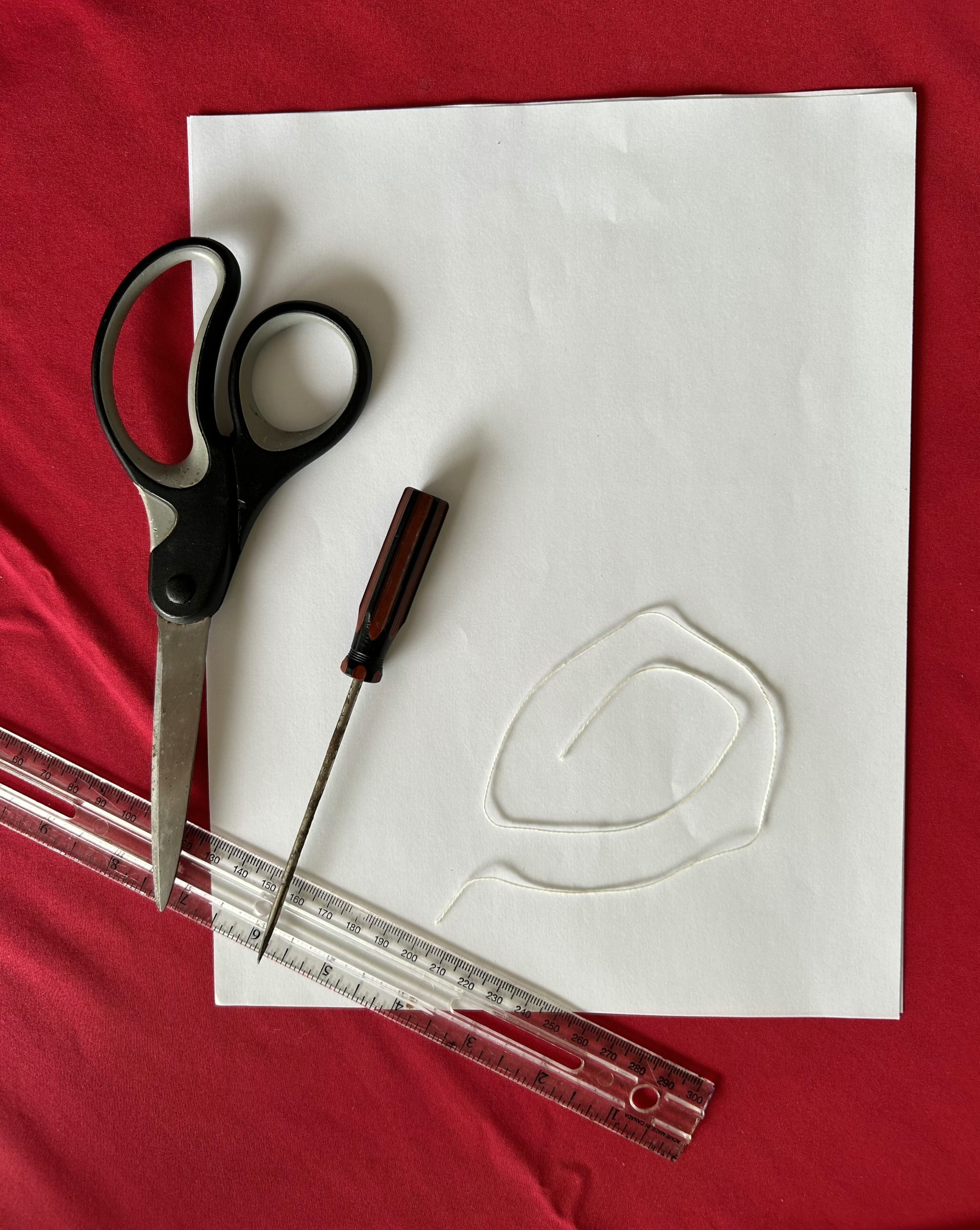 Paper, scissors, twine, ruler, and an awl.