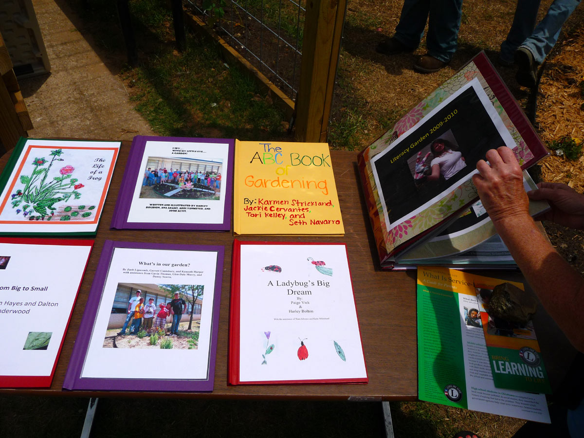 Keli_Books_Finished Folders with colorful handmade covers on a table. Ones is being opened by a child.