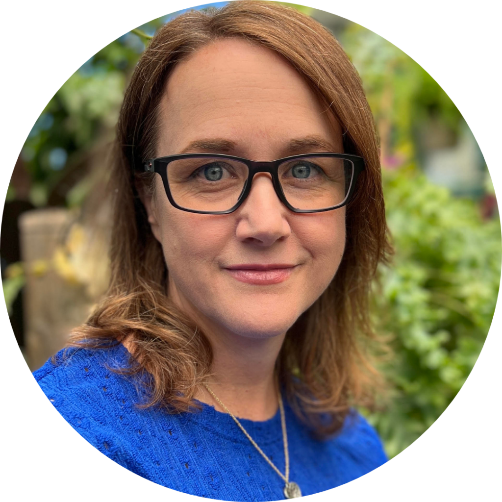 Christie Kane, a person with brown hair wearing glasses and a blue shirt
