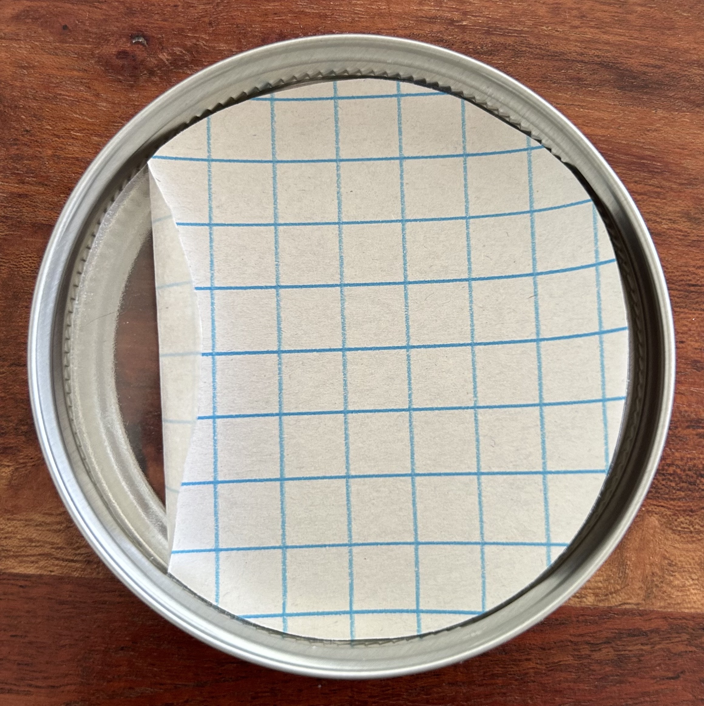 graph paper / contact paper situated in a jar lid