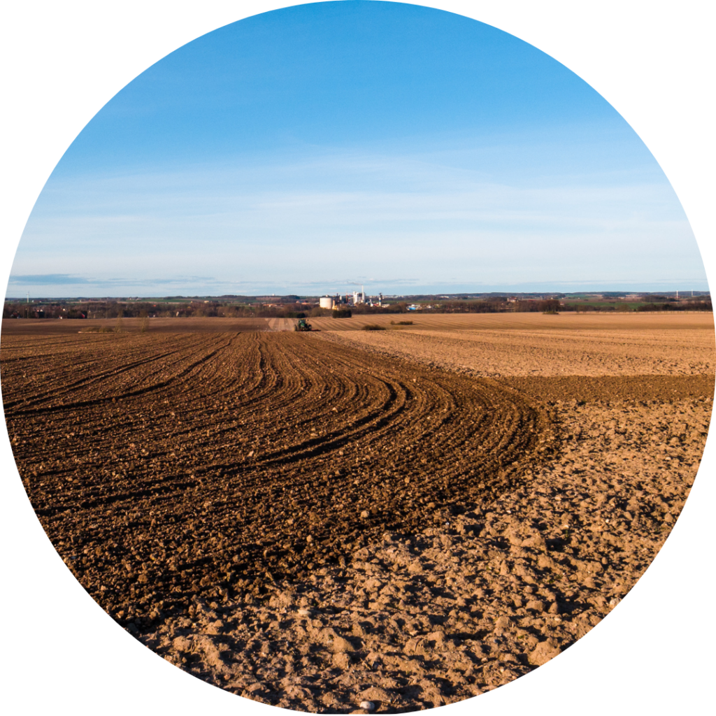 A plowed field with a blue sky in the horizon