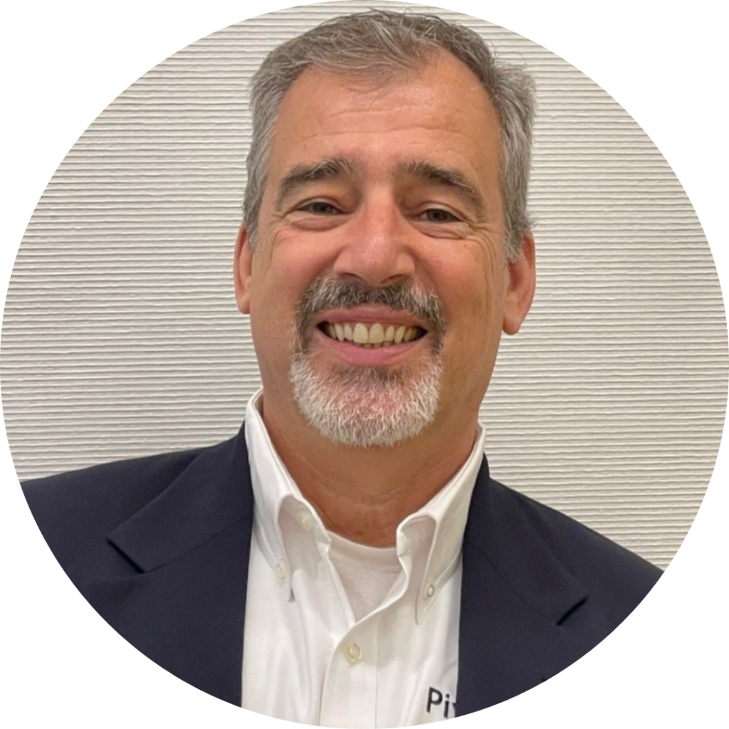 Ken Lane, a white man with gray hair and beard. He is wearing a black jacket and white shirt.