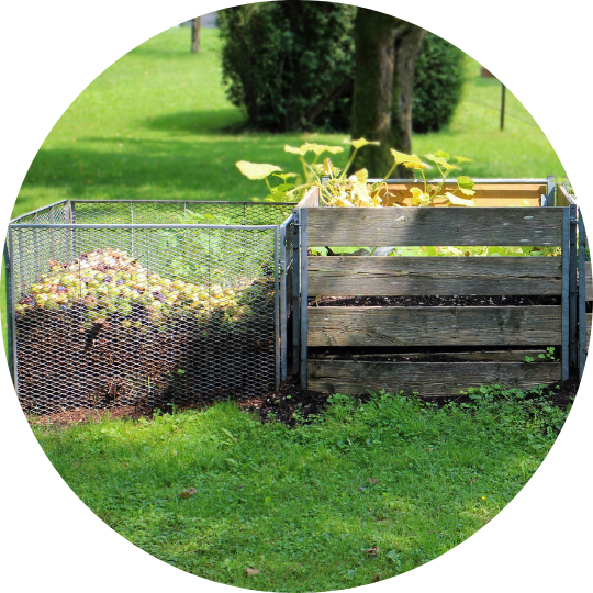 Compost in a chain link fence and compost in a wooden box.