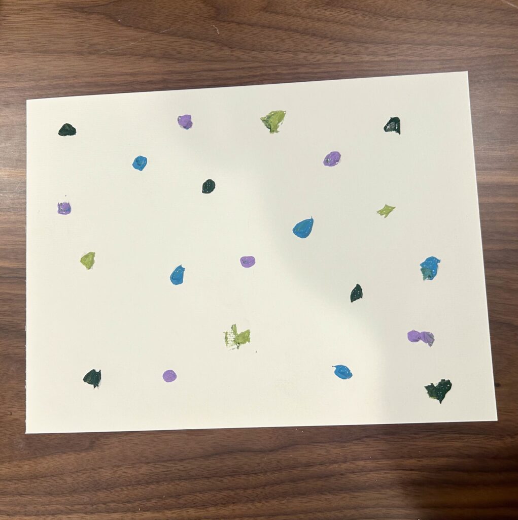 Dots of paint on a piece of white paper.