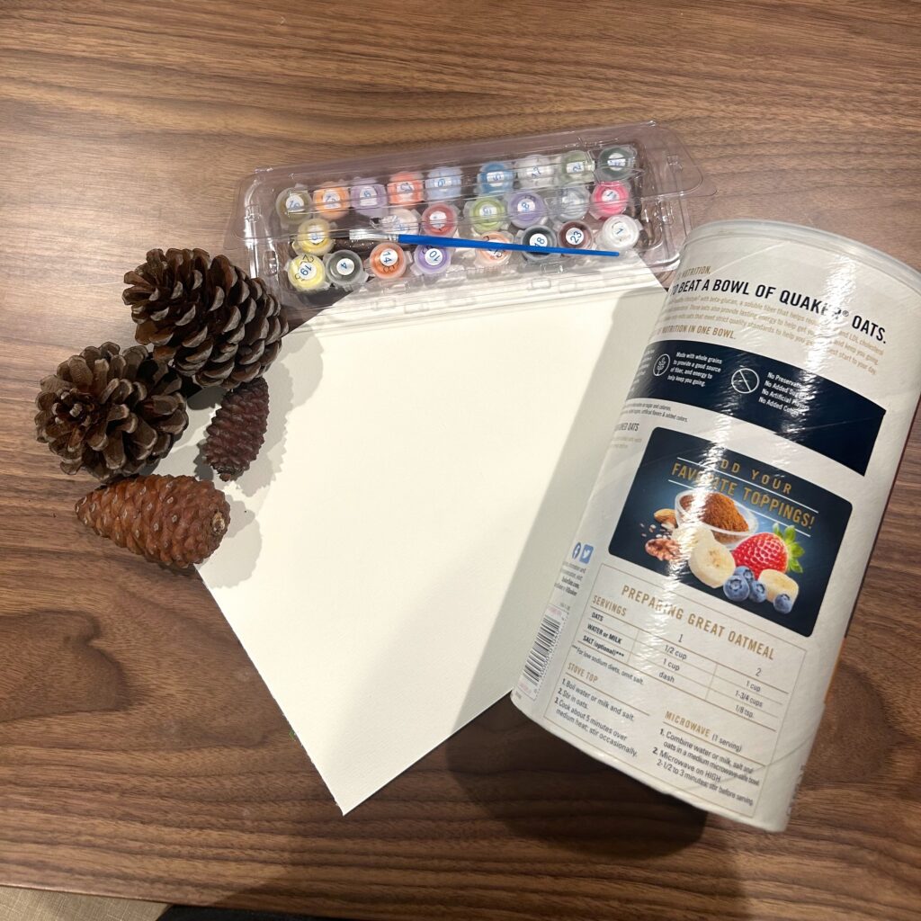 Pinecones, paint, paper, and an oatmeal canister.